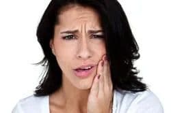 Woman holding her mouth in pain